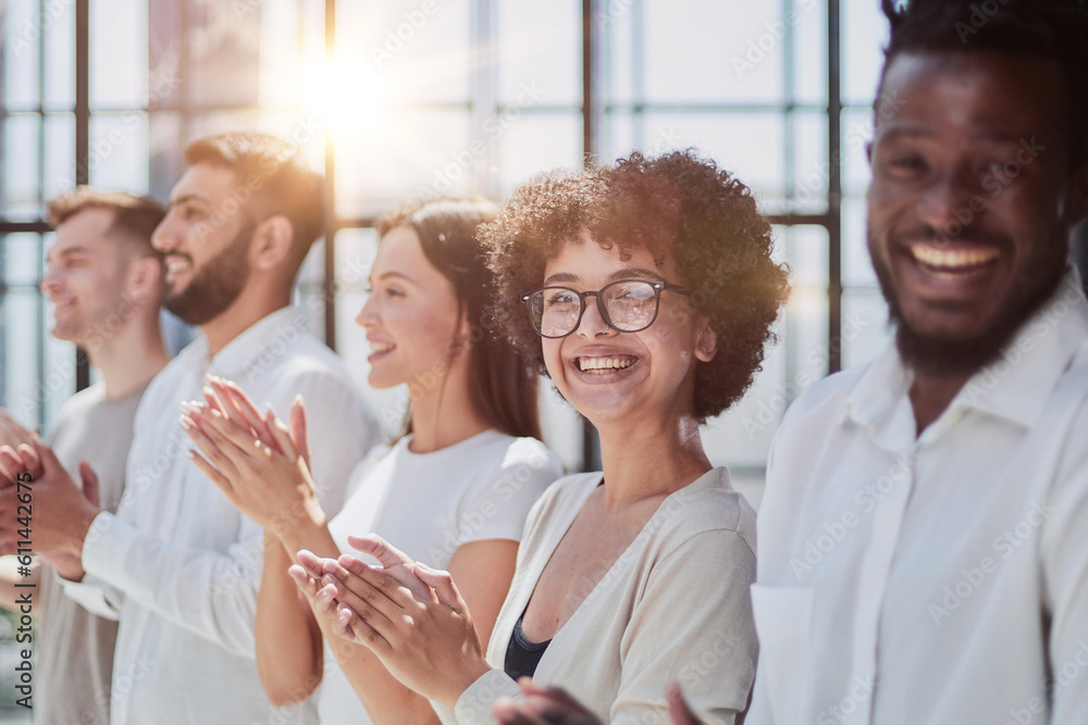 Group of businesspeople sitting in a line and applauding. Group of businesspeople sitting in a line and applauding.