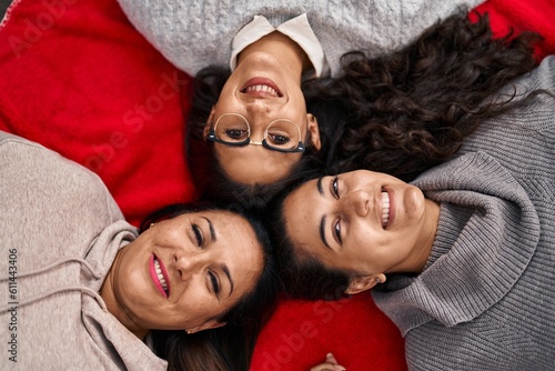 Three woman smiling confident lying on blanket at home