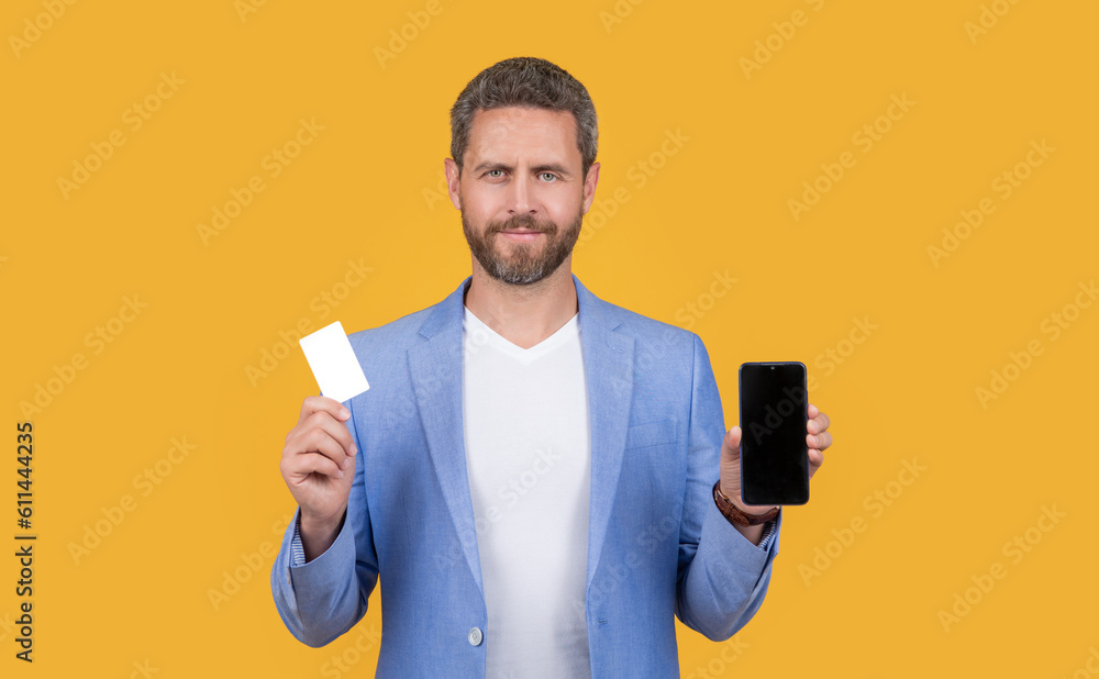 smiling man paying ecommerce online isolated on yellow. man paying online in studio. smiling man paying ecommerce online isolated on yellow. man paying online in studio.