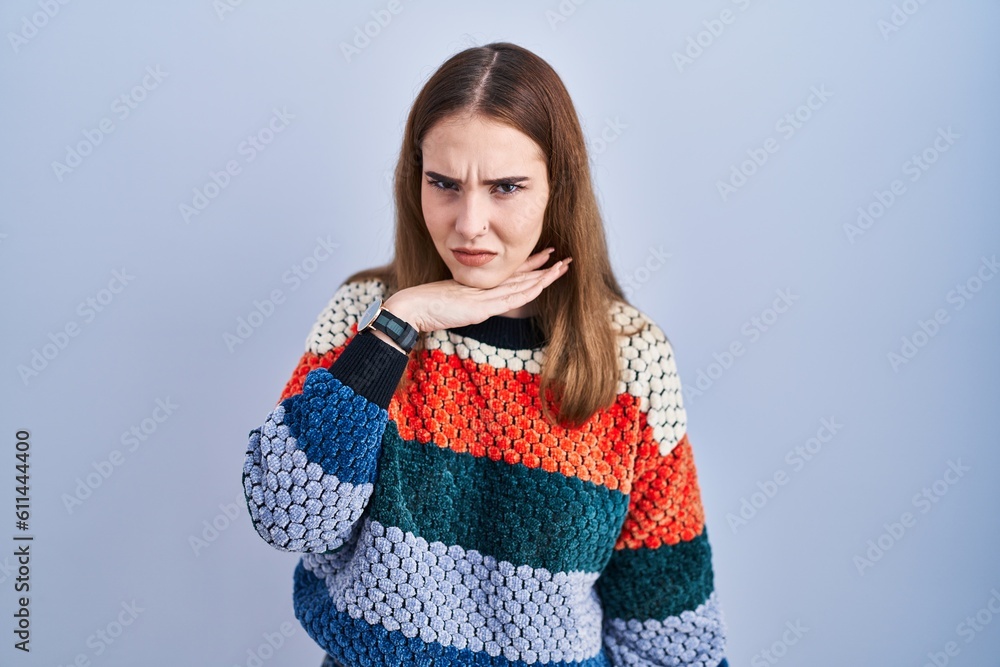 Young hispanic girl standing over blue background cutting throat with hand as knife, threaten aggression with furious violence Young hispanic girl standing over blue background cutting throat with hand as knife, threaten aggression with furious violence