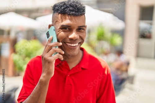 Young latin man smiling confident talking on the smartphone at street