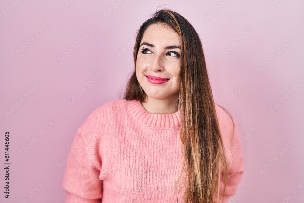Young hispanic woman standing over pink background smiling looking to the side and staring away thinking. Young hispanic woman standing over pink background smiling looking to the side and staring away thinking.