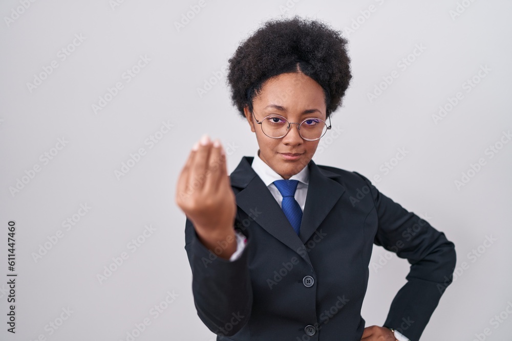 Beautiful african woman with curly hair wearing business jacket and glasses doing italian gesture with hand and fingers confident expression Beautiful african woman with curly hair wearing business jacket and glasses doing italian gesture with hand and fingers confident expression