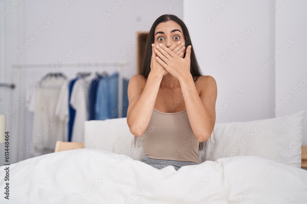 Young brunette woman in the bed at home shocked covering mouth with hands for mistake. secret concept. Young brunette woman in the bed at home shocked covering mouth with hands for mistake. secret concept.
