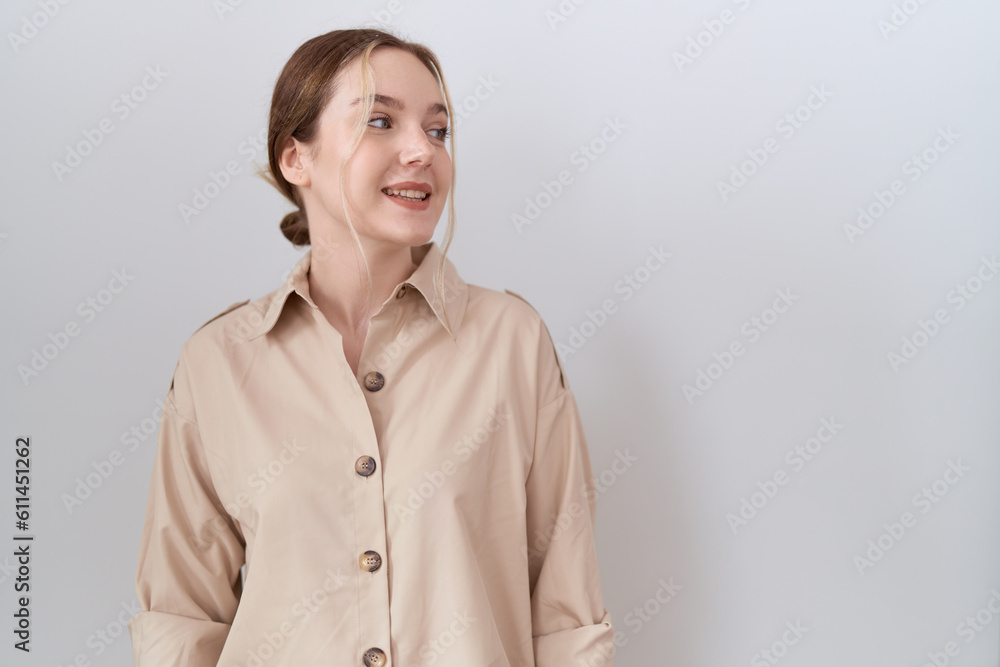 Young caucasian woman wearing casual shirt looking away to side with smile on face, natural expression. laughing confident. Young caucasian woman wearing casual shirt looking away to side with smile on face, natural expression. laughing confident.