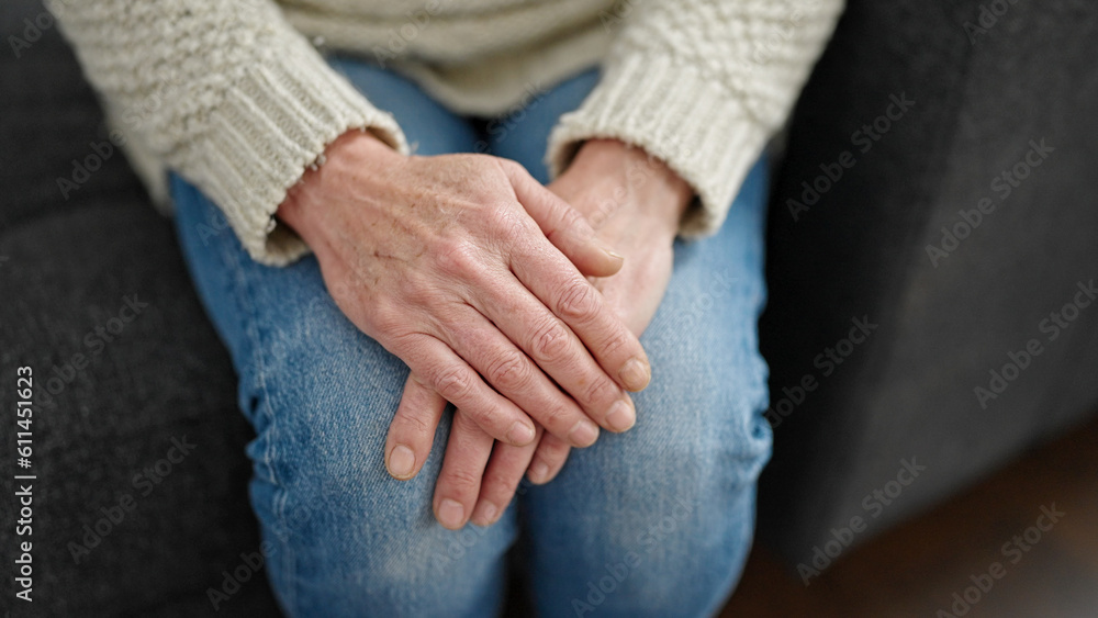 Mature hispanic woman with hands over knees at home Mature hispanic woman with hands over knees at home