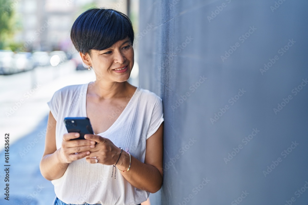 Middle age chinese woman smiling confident using smartphone at street Middle age chinese woman smiling confident using smartphone at street
