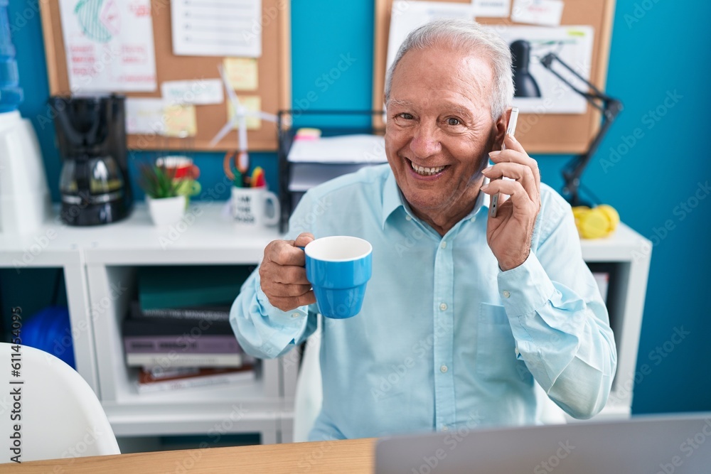 Middle age grey-haired man business worker talking on smartphone drinking coffee at office Middle age grey-haired man business worker talking on smartphone drinking coffee at office