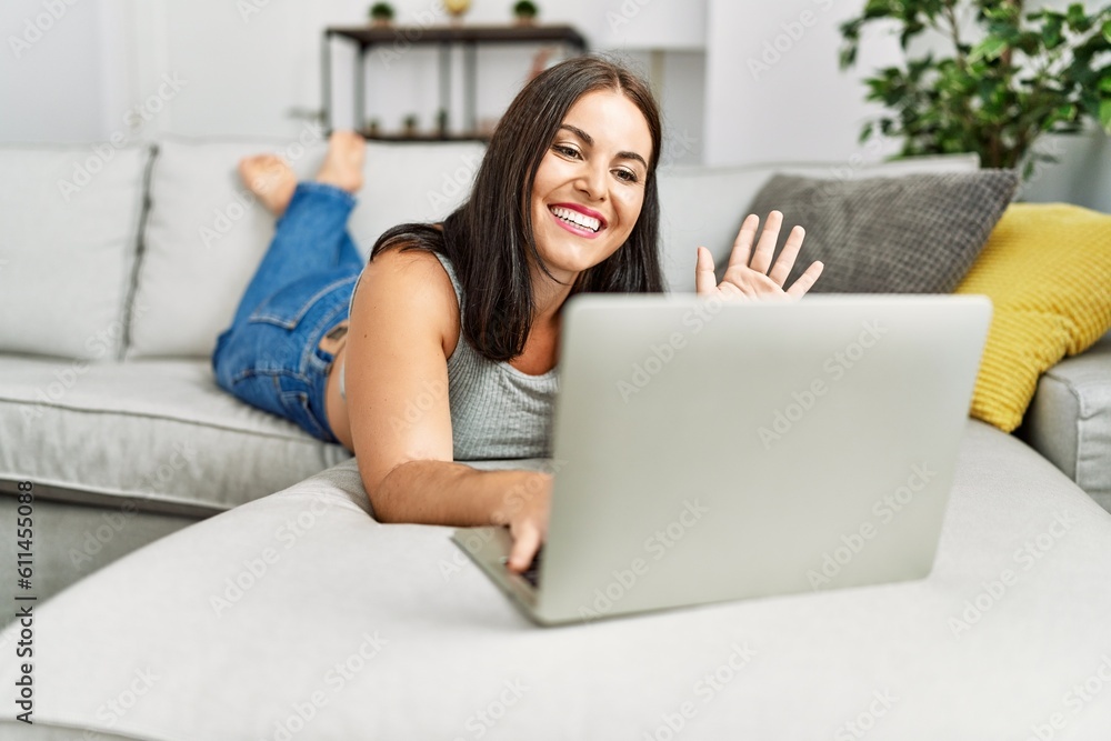 Young beautiful hispanic woman having video call lying on sofa at home Young beautiful hispanic woman having video call lying on sofa at home