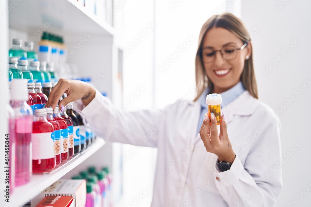 Young beautiful hispanic woman pharmacist smiling confident holding pills bottle at pharmacy Young beautiful hispanic woman pharmacist smiling confident holding pills bottle at pharmacy