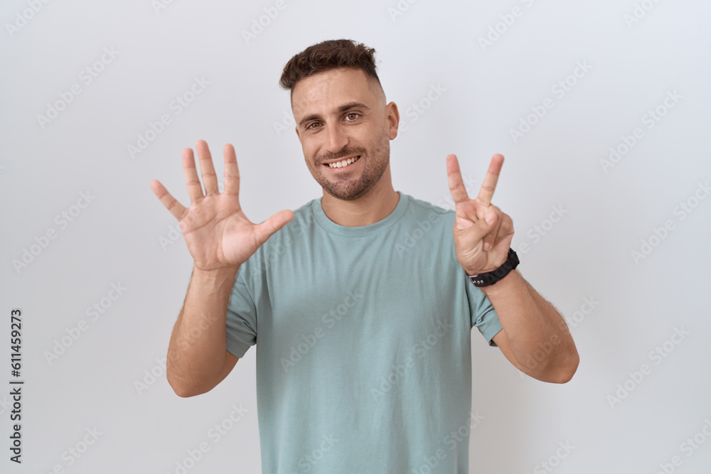 Hispanic man with beard standing over white background showing and pointing up with fingers number seven while smiling confident and happy. Hispanic man with beard standing over white background showing and pointing up with fingers number seven while smiling confident and happy.