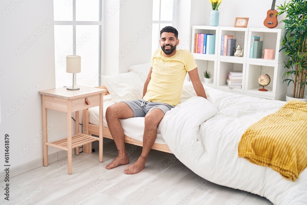 Young arab man smiling confident sitting on bed at bedroom Young arab man smiling confident sitting on bed at bedroom