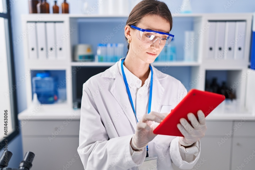Young caucasian woman scientist using touchpad at laboratory Young caucasian woman scientist using touchpad at laboratory