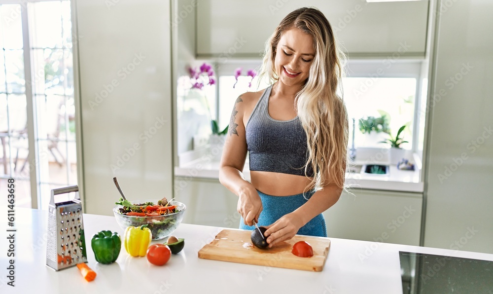Young woman smiling confident cutting avocado for salad at kitchen Young woman smiling confident cutting avocado for salad at kitchen