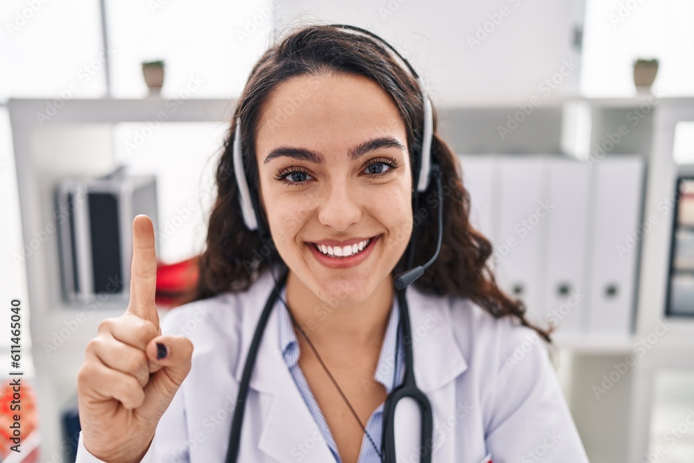 Young doctor woman working on online appointment smiling with an idea or question pointing finger with happy face, number one Young doctor woman working on online appointment smiling with an idea or question pointing finger with happy face, number one