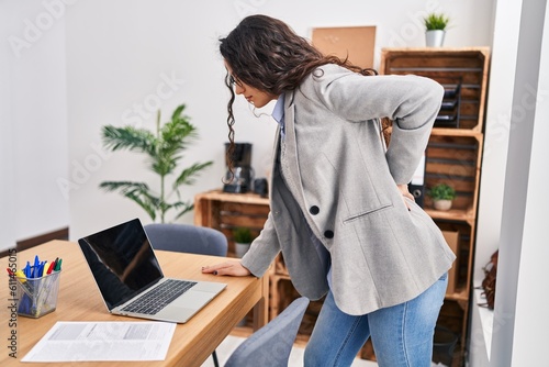 Young hispanic woman business worker suffering for backache at office