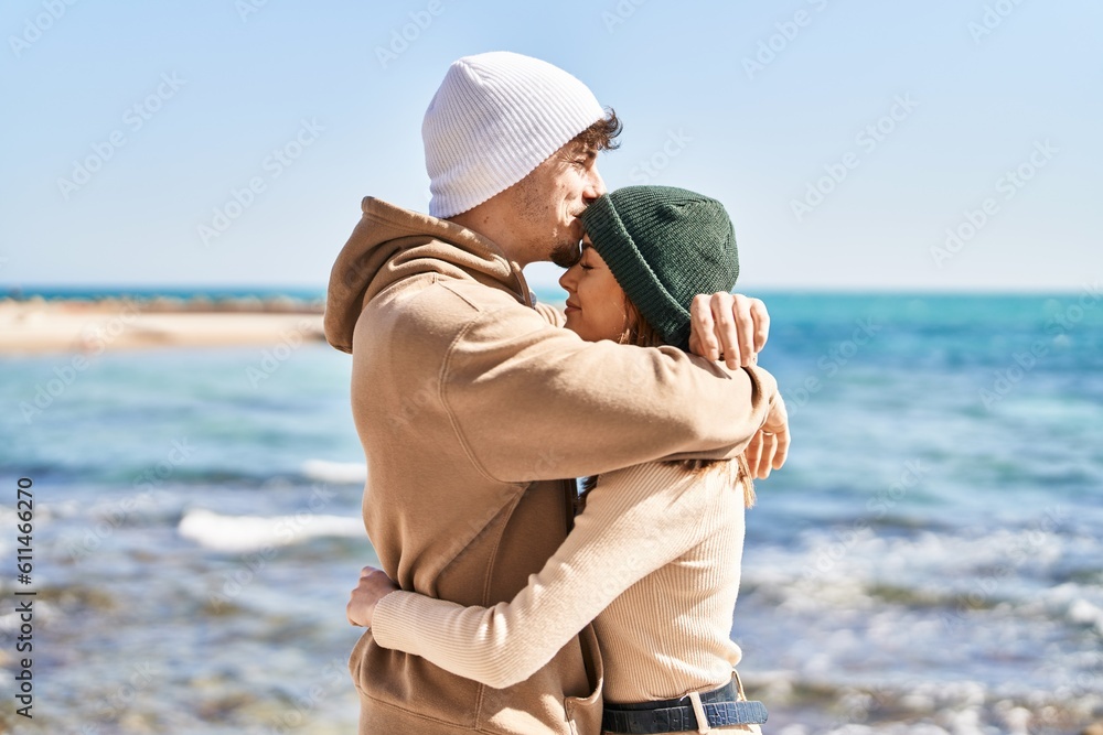 Mand and woman couple hugging each other and kissing at seaside