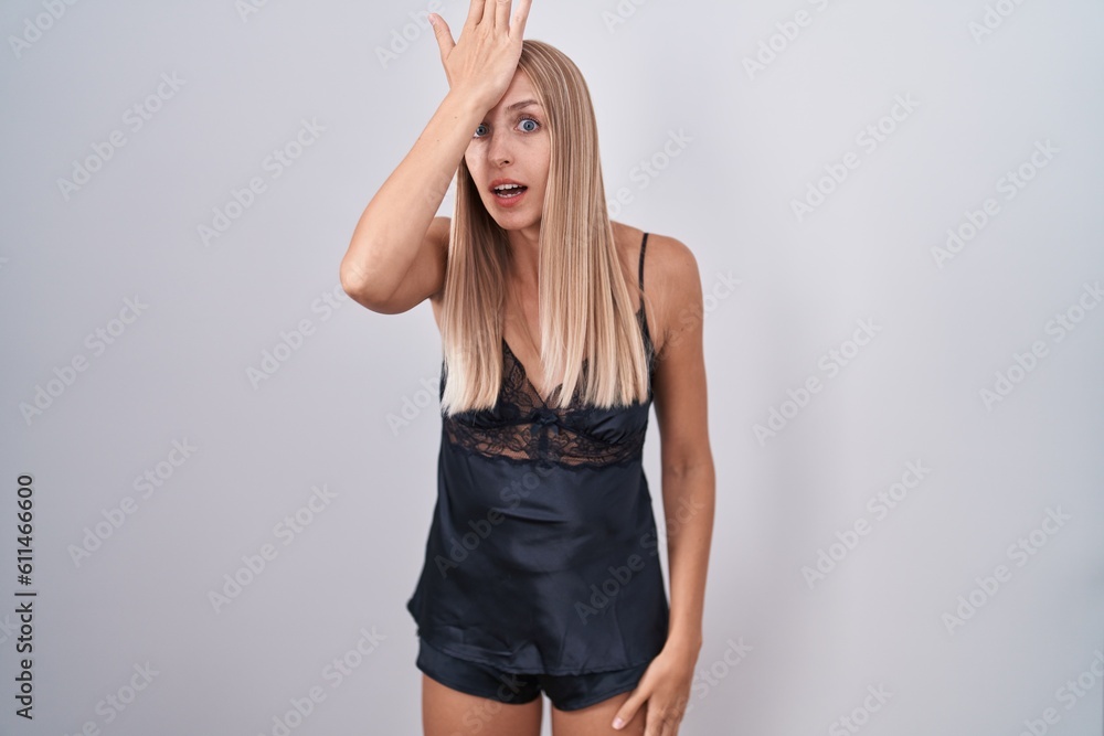 Young caucasian woman wearing nightgown surprised with hand on head for mistake, remember error. forgot, bad memory concept. Young caucasian woman wearing nightgown surprised with hand on head for mistake, remember error. forgot, bad memory concept.