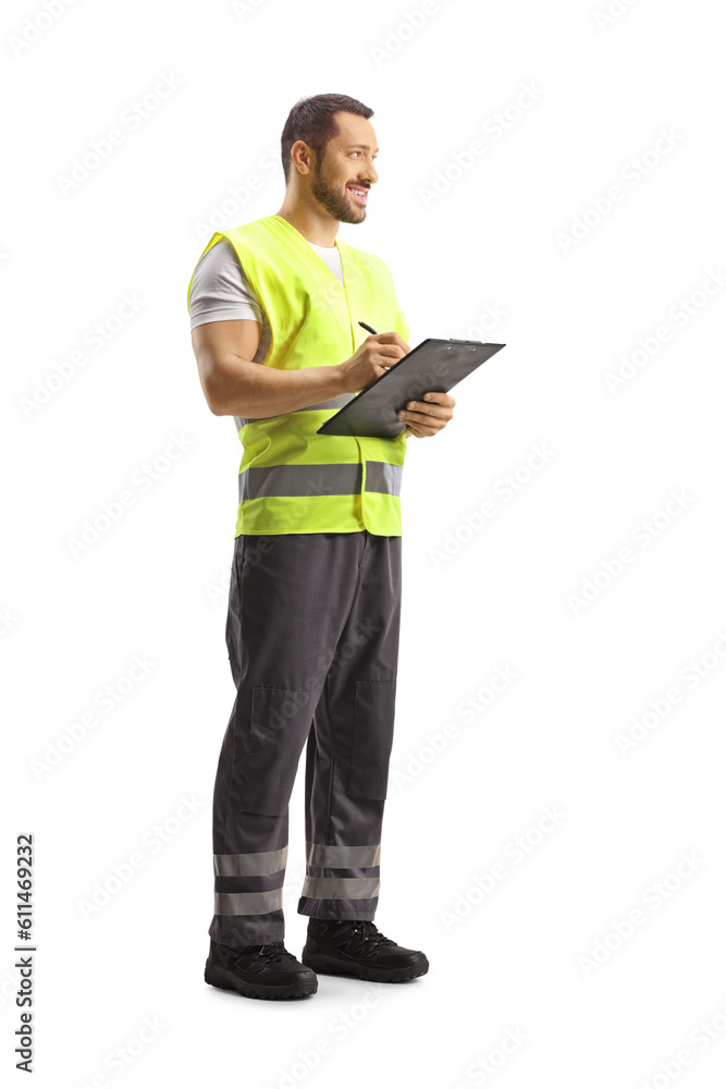 Full length shot of a worker in a reflective vest writing a document and smiling Full length shot of a worker in a reflective vest writing a document and smiling