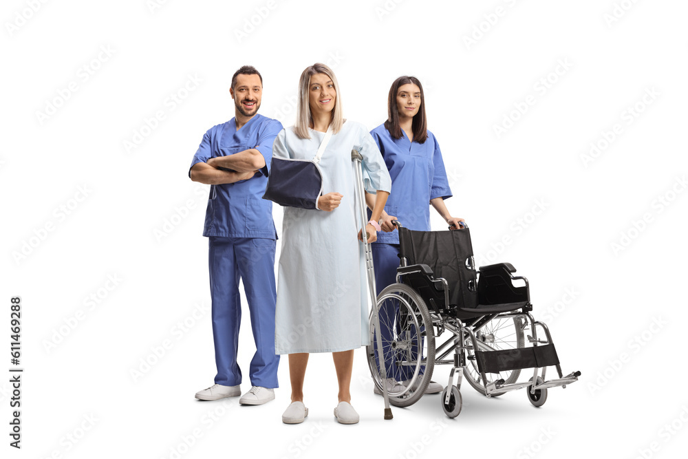 Health care workers helping a young woman in a hospital gown with a broken arm Health care workers helping a young woman in a hospital gown with a broken arm