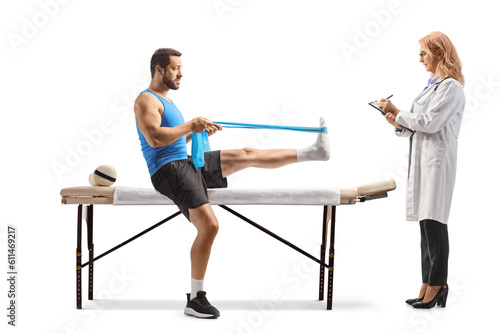 Man sitting on a therapy bed with a female doctor and exercising with a resistance band
