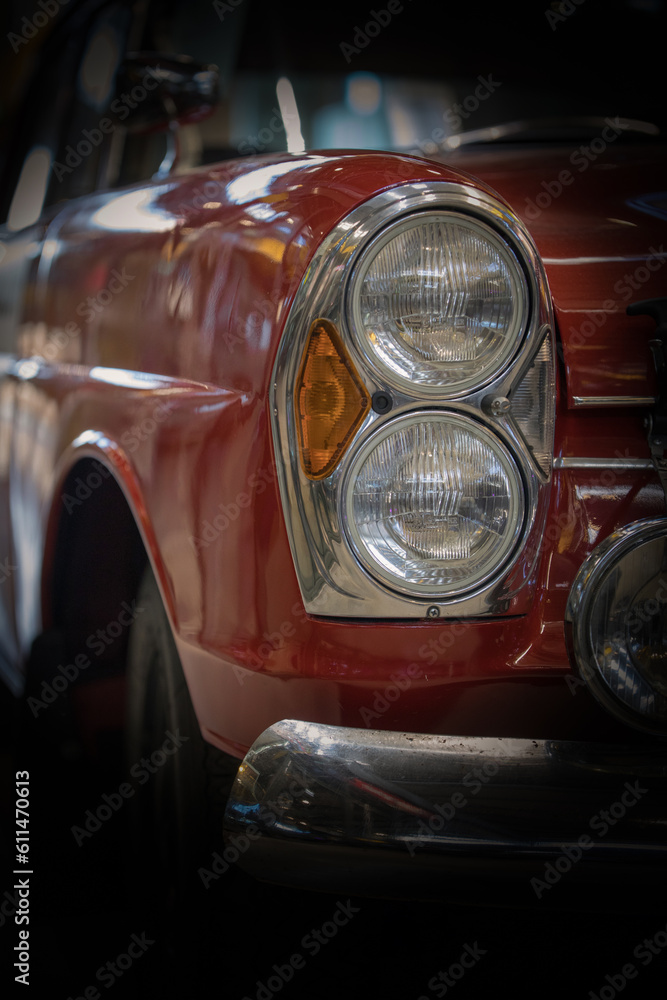 Headlight and hood of the old red car.