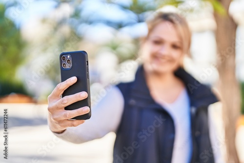 Young blonde woman smiling confident making selfie by the smartphone at park