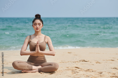 Young woman sitting in lotus position with her eyes closed