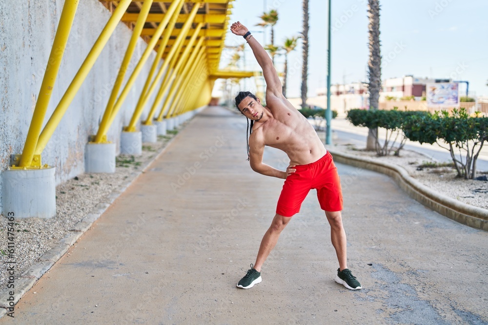 Obraz premium Young man stretching back at street