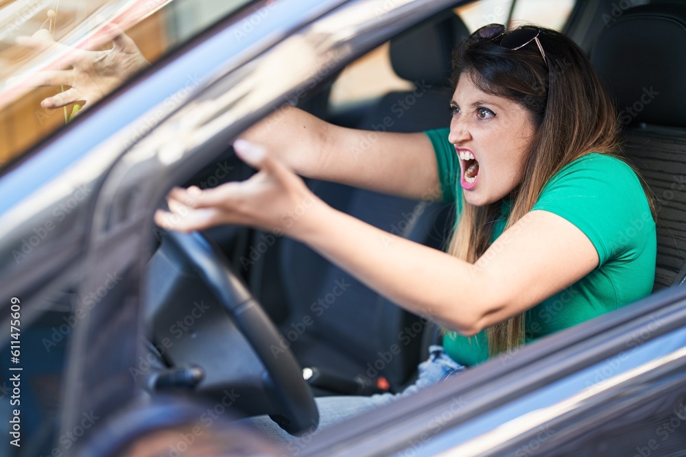 Young hispanic woman furious driving car at street Young hispanic woman furious driving car at street