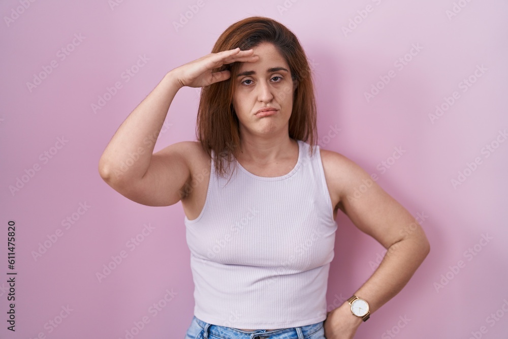 Brunette woman standing over pink background worried and stressed about a problem with hand on forehead, nervous and anxious for crisis Brunette woman standing over pink background worried and stressed about a problem with hand on forehead, nervous and anxious for crisis