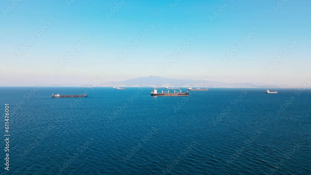 Established aerial shot of bulker or bulk cargo ship on anchor in sea Established aerial shot of bulker or bulk cargo ship on anchor in sea