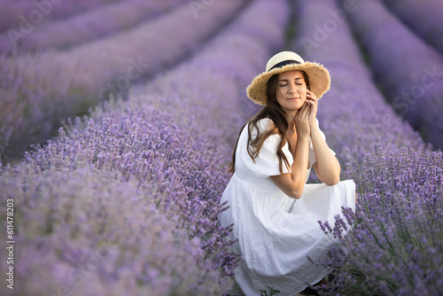 Portrait of dreaming european middle age woman with closed eyes relaxing in nature lavender field. Eco tourism and healthy lifestyle.