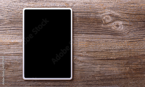 White tablet on a a wooden background.