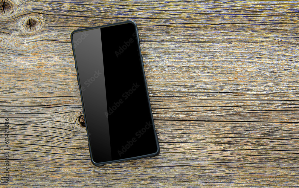 Black smartphone on a wooden table.