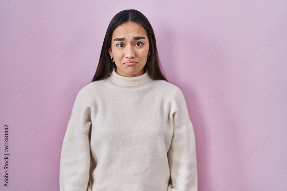 Young south asian woman standing over pink background depressed and worry for distress, crying angry and afraid. sad expression.