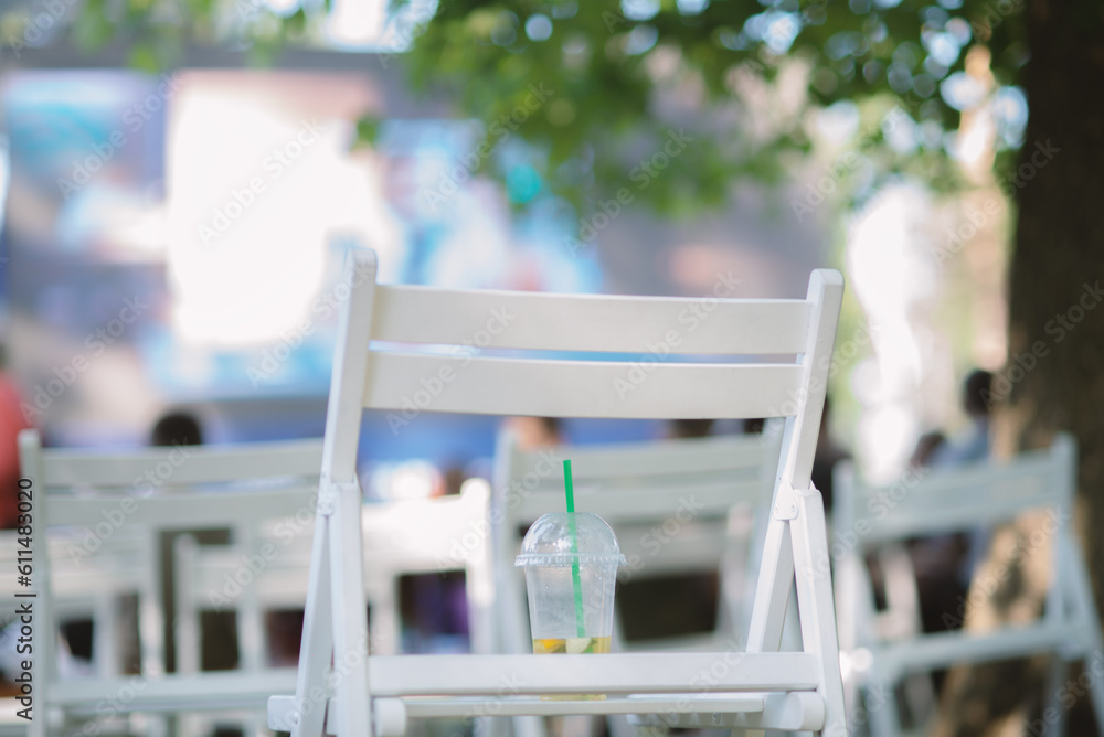 An unfinished lemonade stands on a chair in a summer cinema. An unfinished lemonade stands on a chair in a summer cinema.
