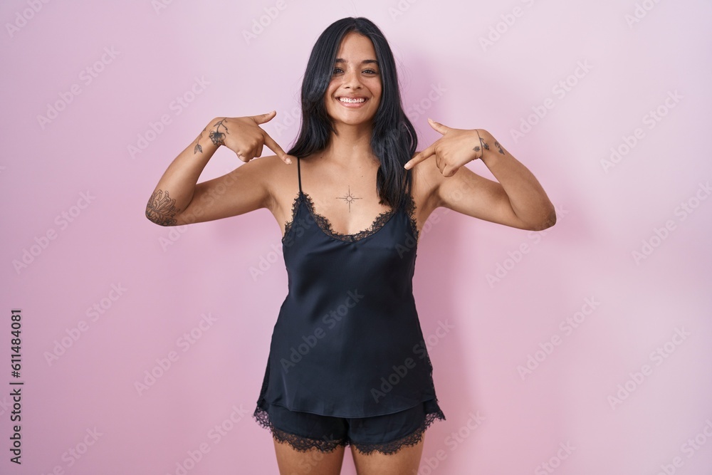 Brunette woman wearing black pajama looking confident with smile on face, pointing oneself with fingers proud and happy. Brunette woman wearing black pajama looking confident with smile on face, pointing oneself with fingers proud and happy.