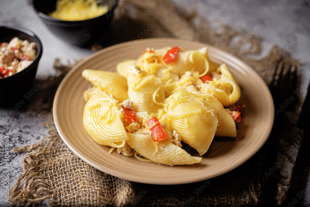 Conchiglie pasta with minced chicken, red pepper and ricotta cheese in a plate