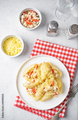 Conchiglie pasta with minced chicken, red pepper and ricotta cheese in a plate