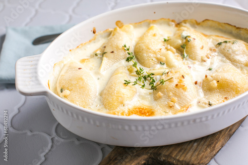 Obraz na plátně cheesy and creamy chicken and shells pasta bake in baking dish on dark grey conc