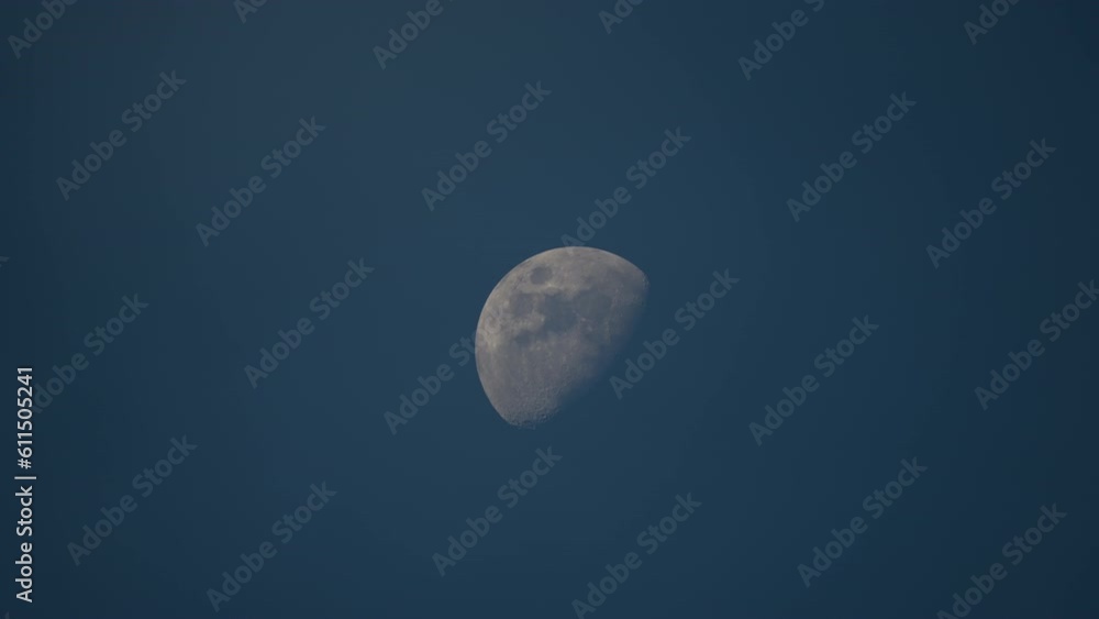 Bright full moon behind fast moving thin layer of clouds on night blue sky Bright full moon behind fast moving thin layer of clouds on night blue sky
