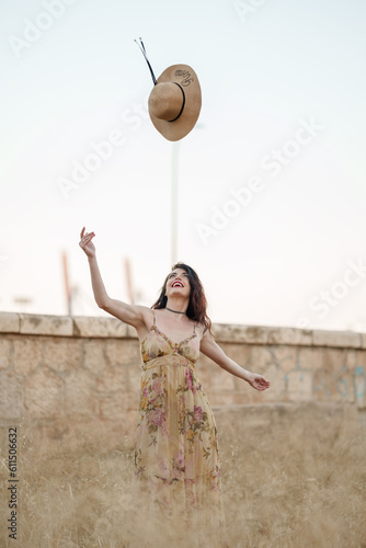Schilderij op canvas attractive girl in a long vintage dress looking at the hat she has thrown into a