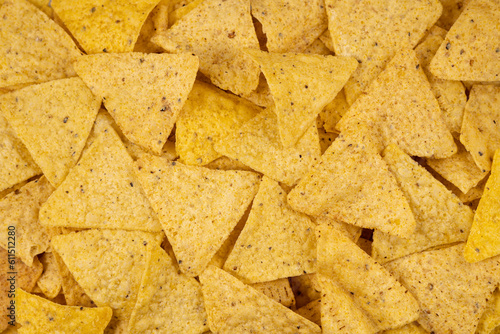 Background of Corn Tortilla Chips or Nachos. Tasty Mexican nachos chips as background, closeup