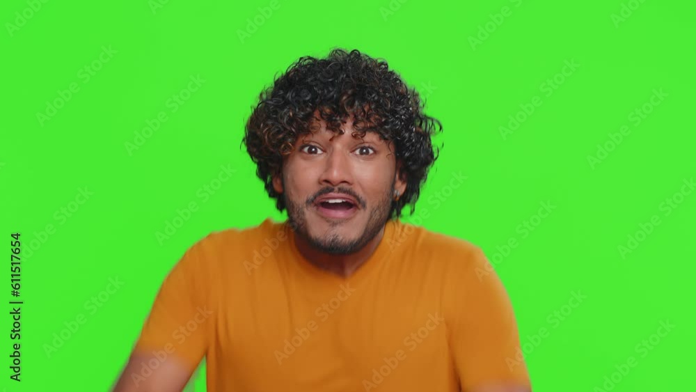 Happy joyful indian man fingers crossed shouting, celebrating success, winning, birthday, lottery jackpot goal achievemen, good news, victory. Young hindu guy isolated on green chroma key background Happy joyful indian man fingers crossed shouting, celebrating success, winning, birthday, lottery jackpot goal achievemen, good news, victory. Young hindu guy isolated on green chroma key background