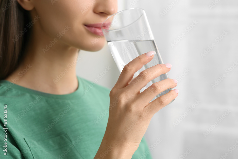 Healthy habit. Woman drinking fresh water from glass indoors, closeup Healthy habit. Woman drinking fresh water from glass indoors, closeup