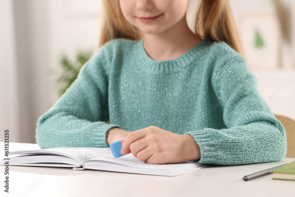 Girl using eraser at white desk indoors, closeup Girl using eraser at white desk indoors, closeup
