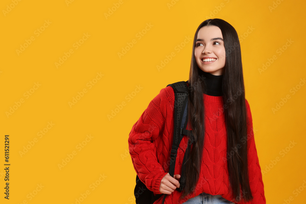 Happy teenage girl with backpack on yellow background. Space for text Happy teenage girl with backpack on yellow background. Space for text