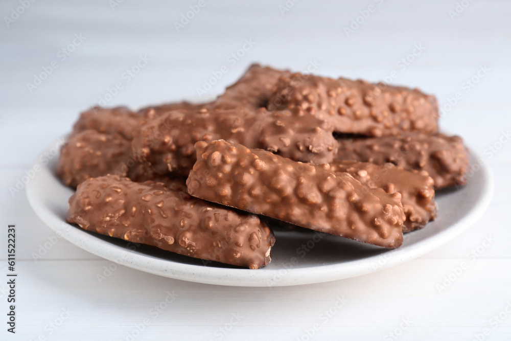 Tasty sweet chocolate bars on white wooden table, closeup Tasty sweet chocolate bars on white wooden table, closeup
