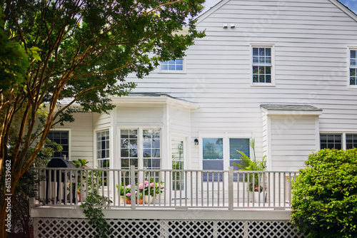 traditional house with white wooden deck in the garden on summer day photo